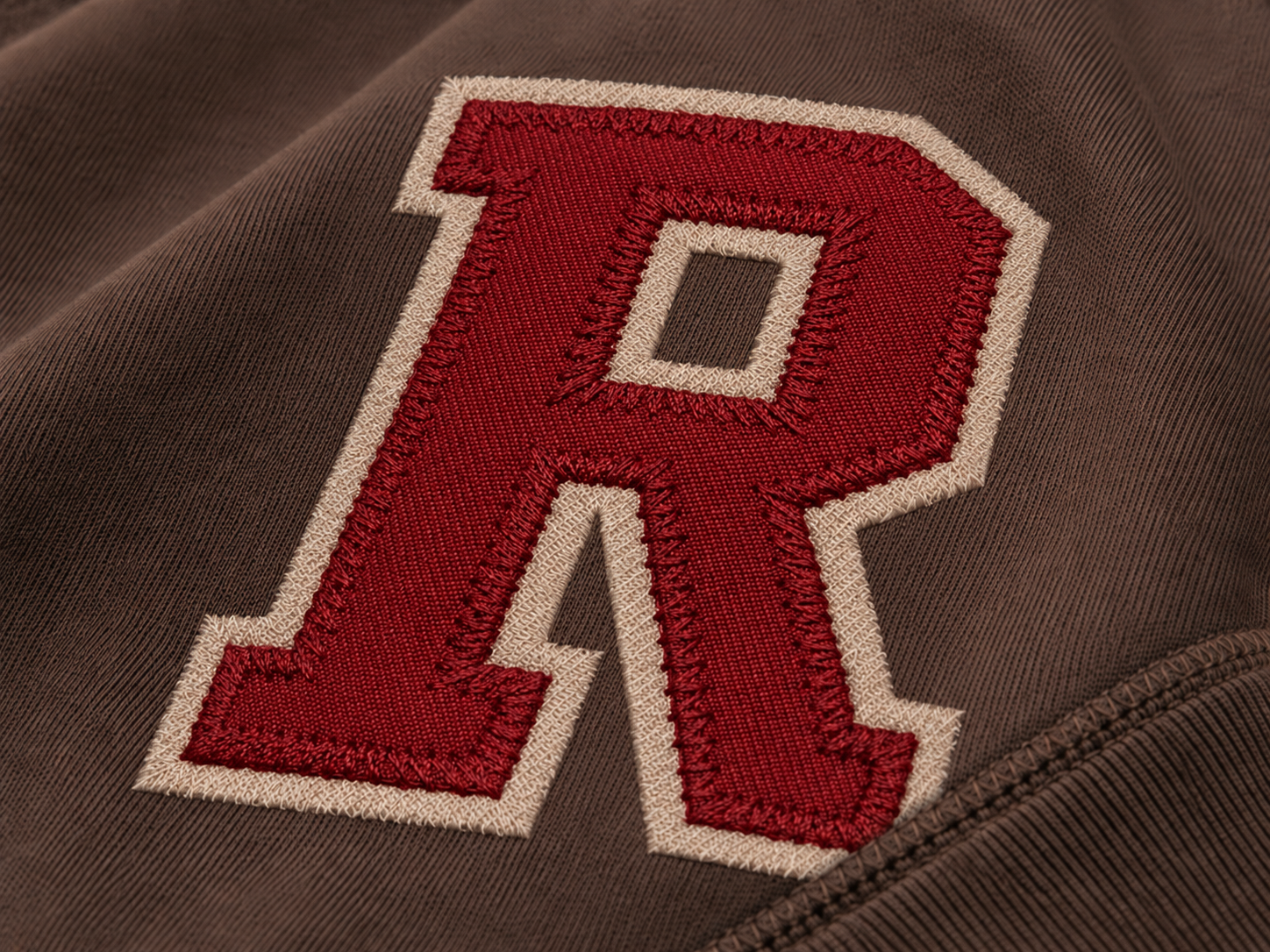 Appliqué and tackle-twill lettering on collegiate apparel
